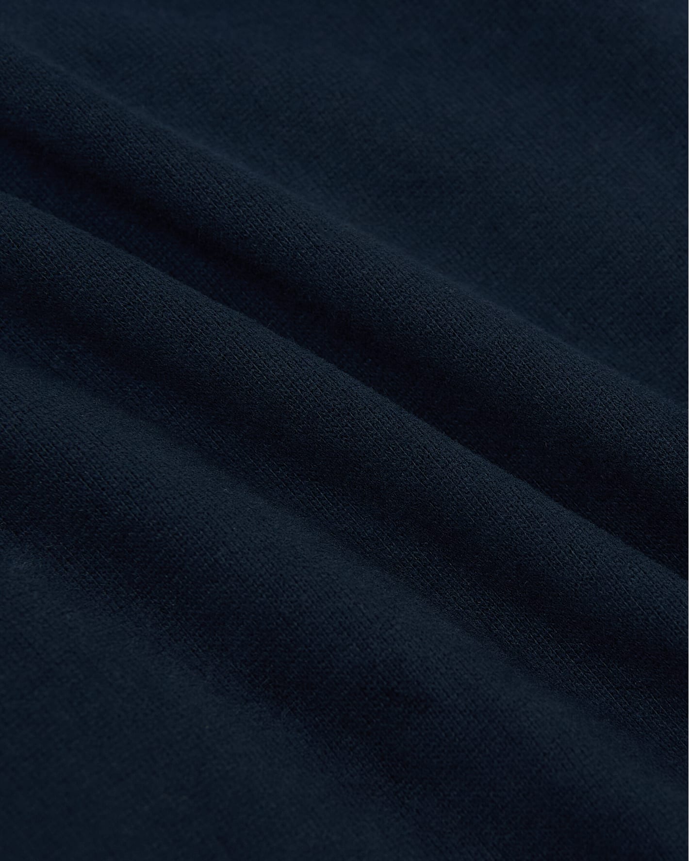 Camiseta de manga larga azul marino de tejido grueso con dobladillo curvo.