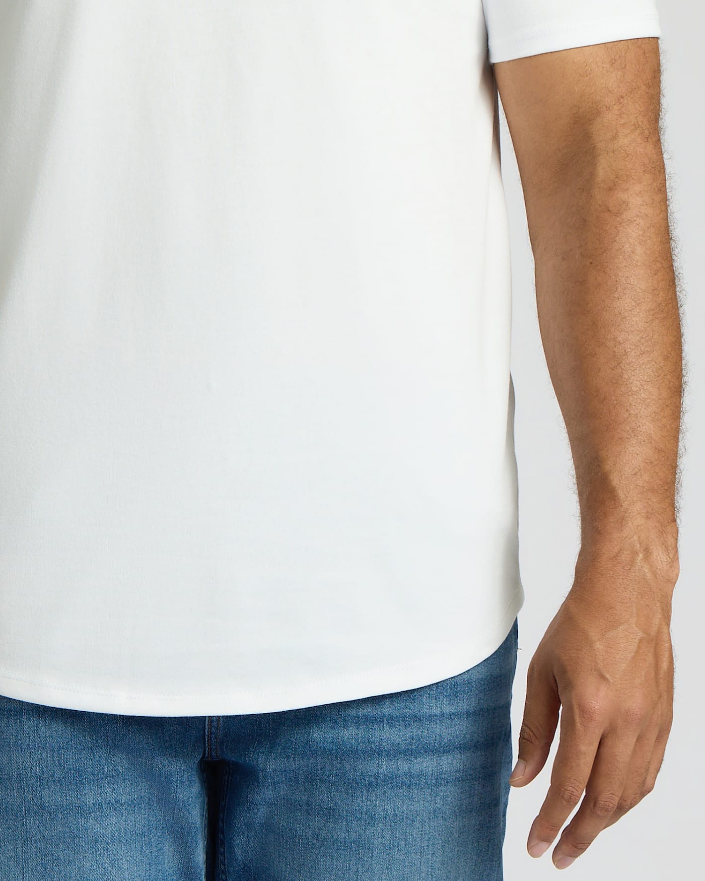Camiseta blanca alta de manga larga con dobladillo curvo.
